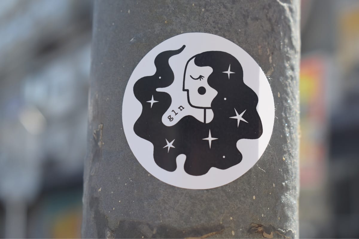 Photo by Marija Zaric a sticker of a woman's face on a pole